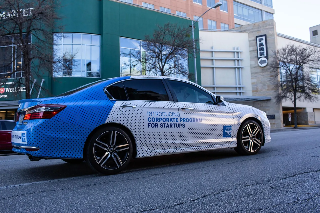 American Express full '360' vinyl wrap on a rideshare vehicle, illustrating full-coverage car-wrap advertising on AdQuick's blog