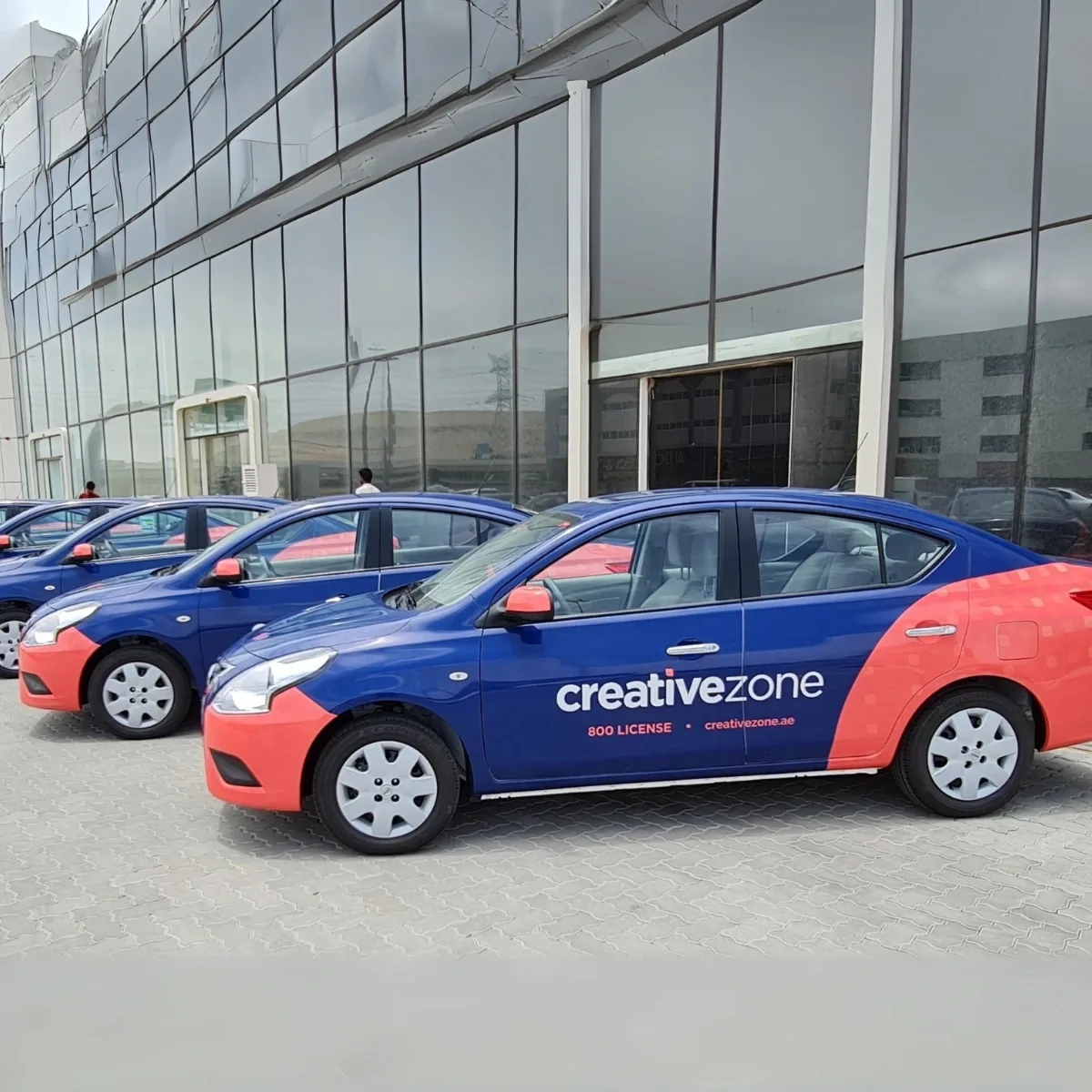 Fleet of Creative Zone blue/red fully-branded Dubai taxis lined up