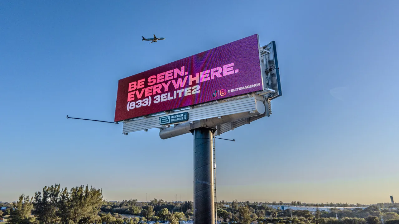 Elite Marketing Agency 'Be Seen. Everywhere.' ad running on a Becker Boards roadside digital billboard (aerial photo), booked through Blip Billboards.