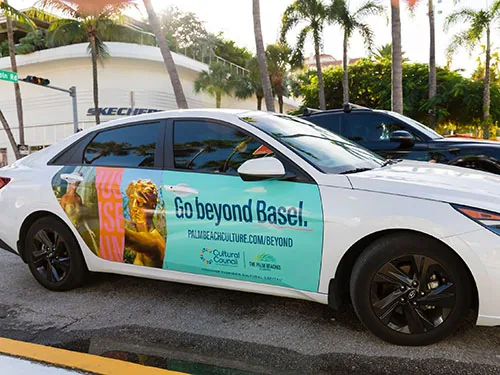 Cultural Council for Palm Beach 'Go Beyond Basel' door-panel wrap on an Uber/Lyft rideshare sedan for Art Basel Miami, placed via Blue Line Media