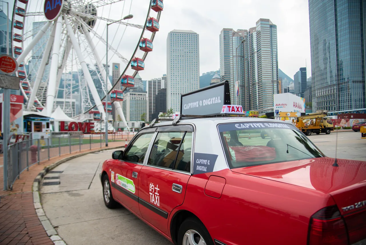 Captive 8 OOH digital taxi-top LED display on a Hong Kong red taxi (homepage hero)