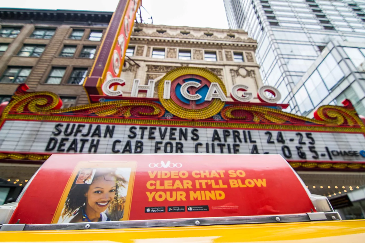 ooVoo 'Video chat so clear it'll blow your mind' taxi-top on a yellow cab beneath the Chicago Theatre marquee — CVA taxi advertising markets page