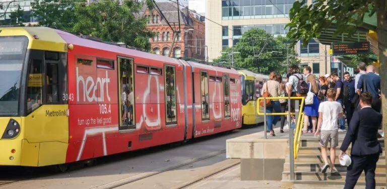 Fully wrapped Manchester Metrolink tram (transit superside) carrying a Heart 105.4 radio campaign at a city-centre stop