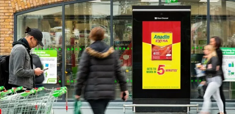 Clear Channel street-level digital DOOH panel showing an Anadin Extra ad outside an ASDA store, real deployment photo