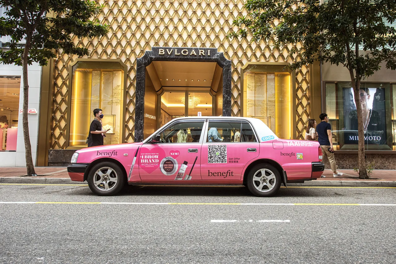 Benefit Cosmetics full-body pink Hong Kong taxi wrap (Superside format) parked outside Bvlgari, with CODY branding on the door