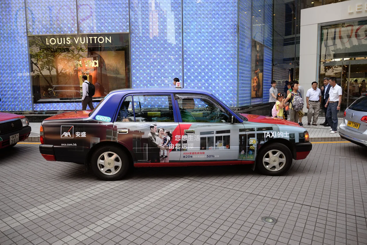 AXA insurance Hong Kong taxi wrap (Megaside format) on a Toyota Comfort taxi outside Louis Vuitton, CODY-branded