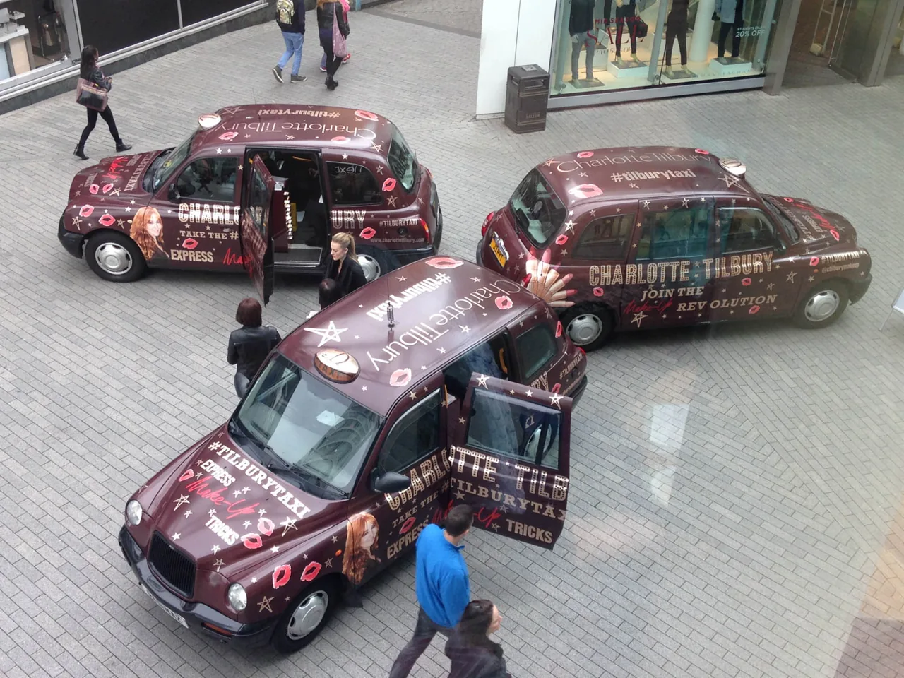 Charlotte Tilbury #TilburyTaxi fleet of three full-livery wrapped black cabs staged in a shopping precinct (Huge Media own work)