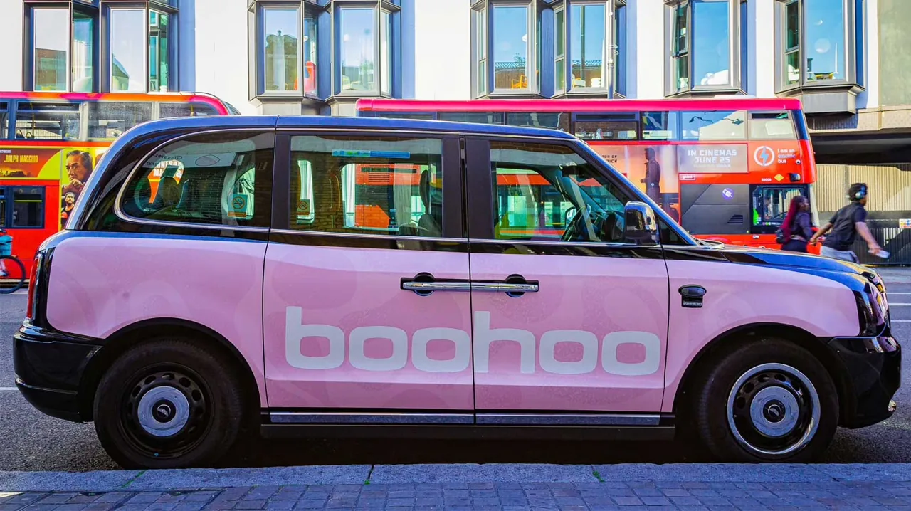 boohoo full-wrap London black cab (pink LEVC TXE electric taxi) on a central London street