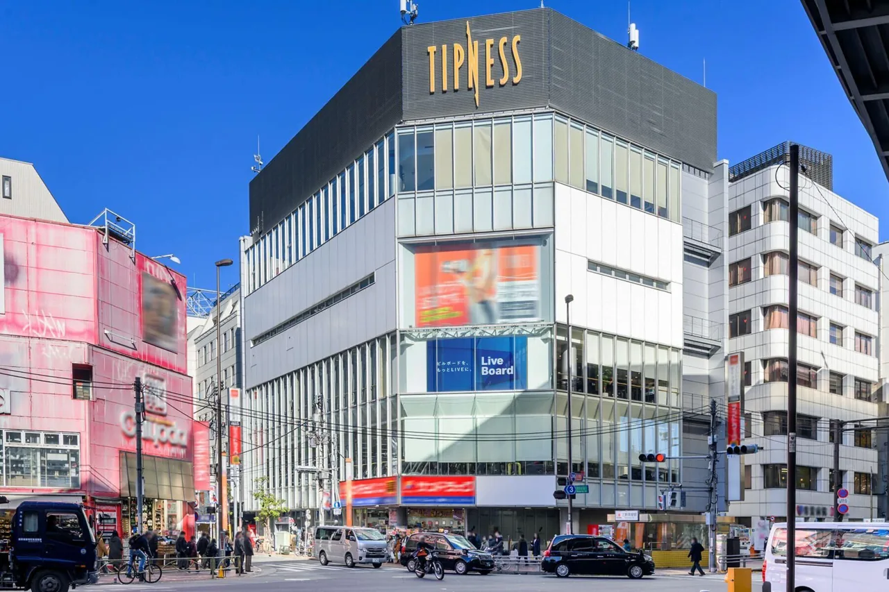 LIVE BOARD digital signage installed at 'Tipness Sangenjaya' by Sangenjaya Station, Tokyo — corner-building digital OOW panel, real street photo.