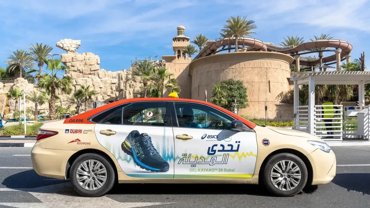 ASICS GEL-KAYANO 28 full-body wrap on a Dubai RTA taxi at Wild Wadi (marketplace listing photo)