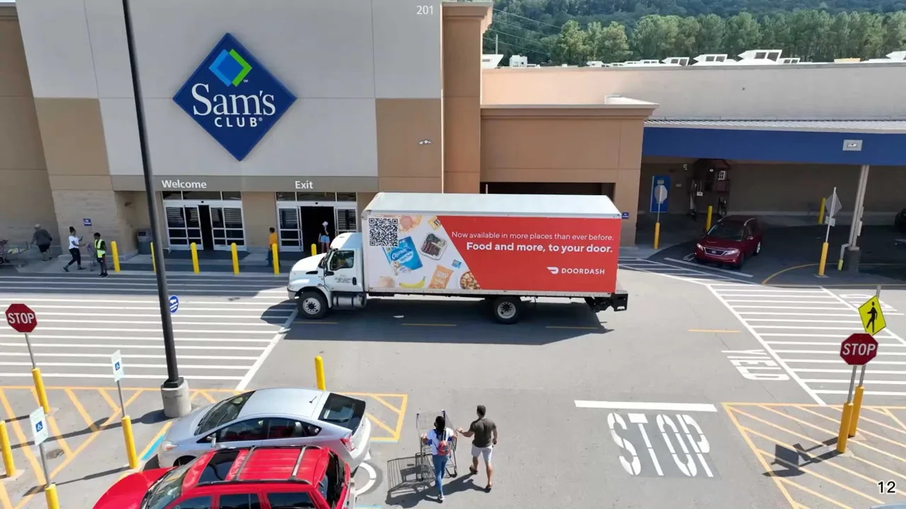 DoorDash "Food and more, to your door" box-truck mobile billboard parked outside a Sam's Club, hero image on Movia Media's homepage.