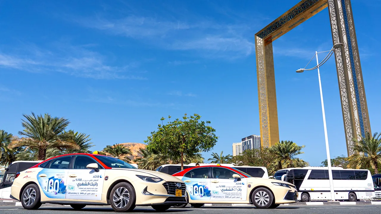 ADIB-branded taxis waiting underneath the Dubai Frame