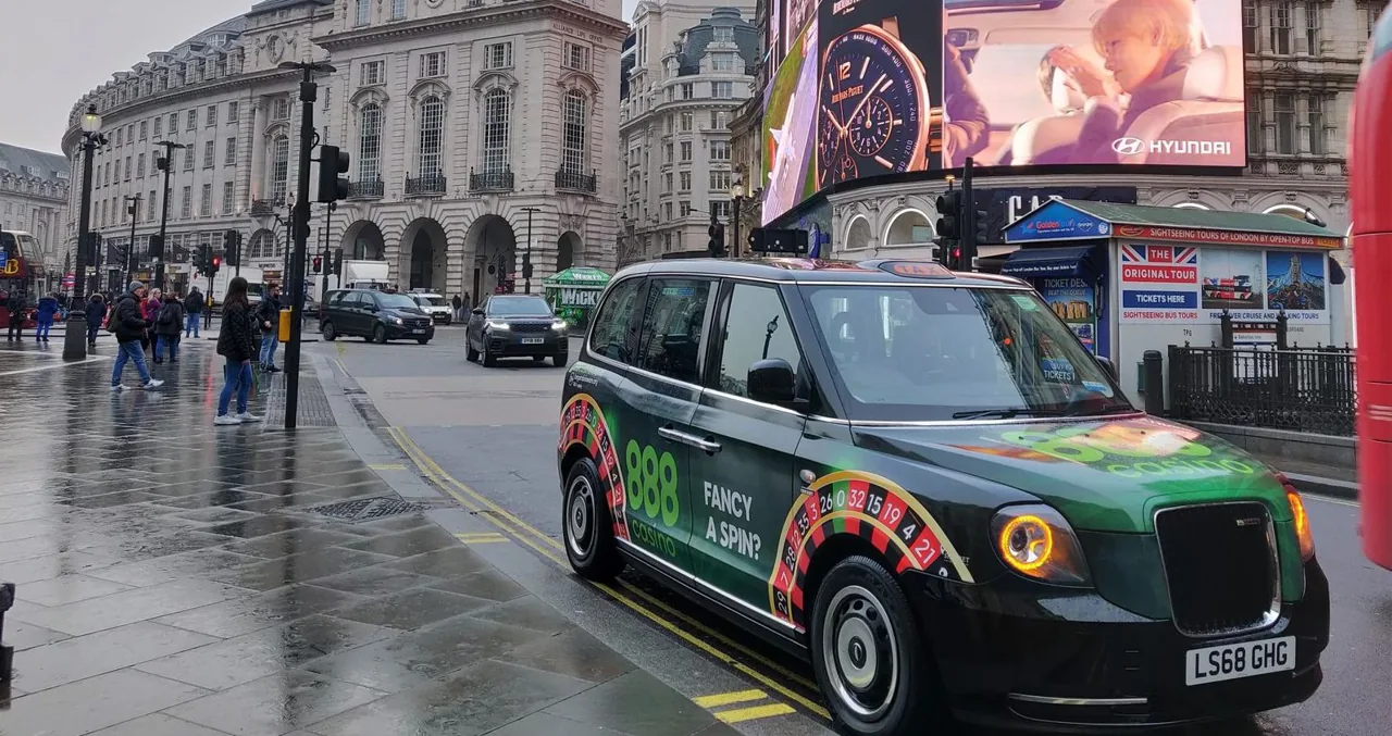 888 Casino London taxi with printed roof artwork and roulette-wheel roof trims ("fancy a spin?")