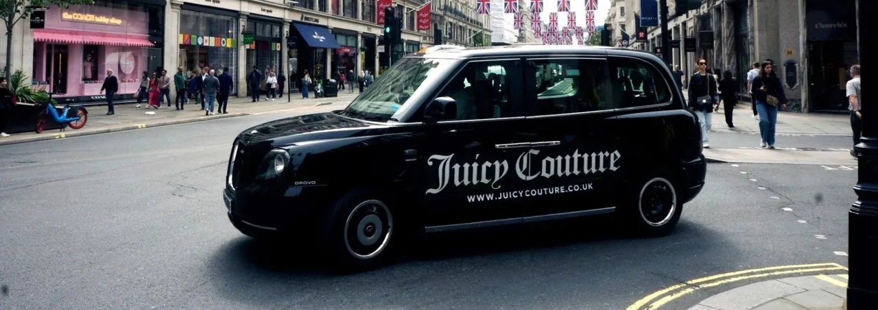 Juicy Couture superside livery on a black London taxi (side-panel taxi advertising format)