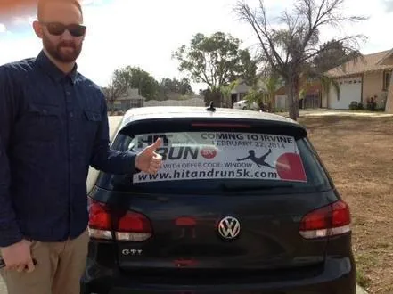 Driver pointing at a VW GTI rear-window decal for the 'Hit and Run 5K' event coming to Irvine (hitandrun5k.com)