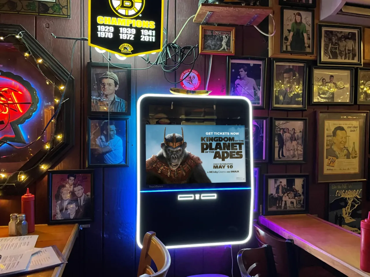 Kingdom of the Planet of the Apes movie ad displayed on a place-based TouchTunes jukebox screen in a bar (Screenverse DOOH network)