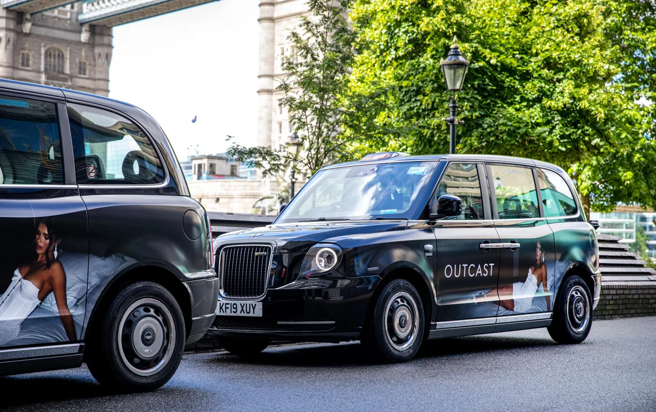 Outcast branded black-cab wraps photographed at Tower Bridge