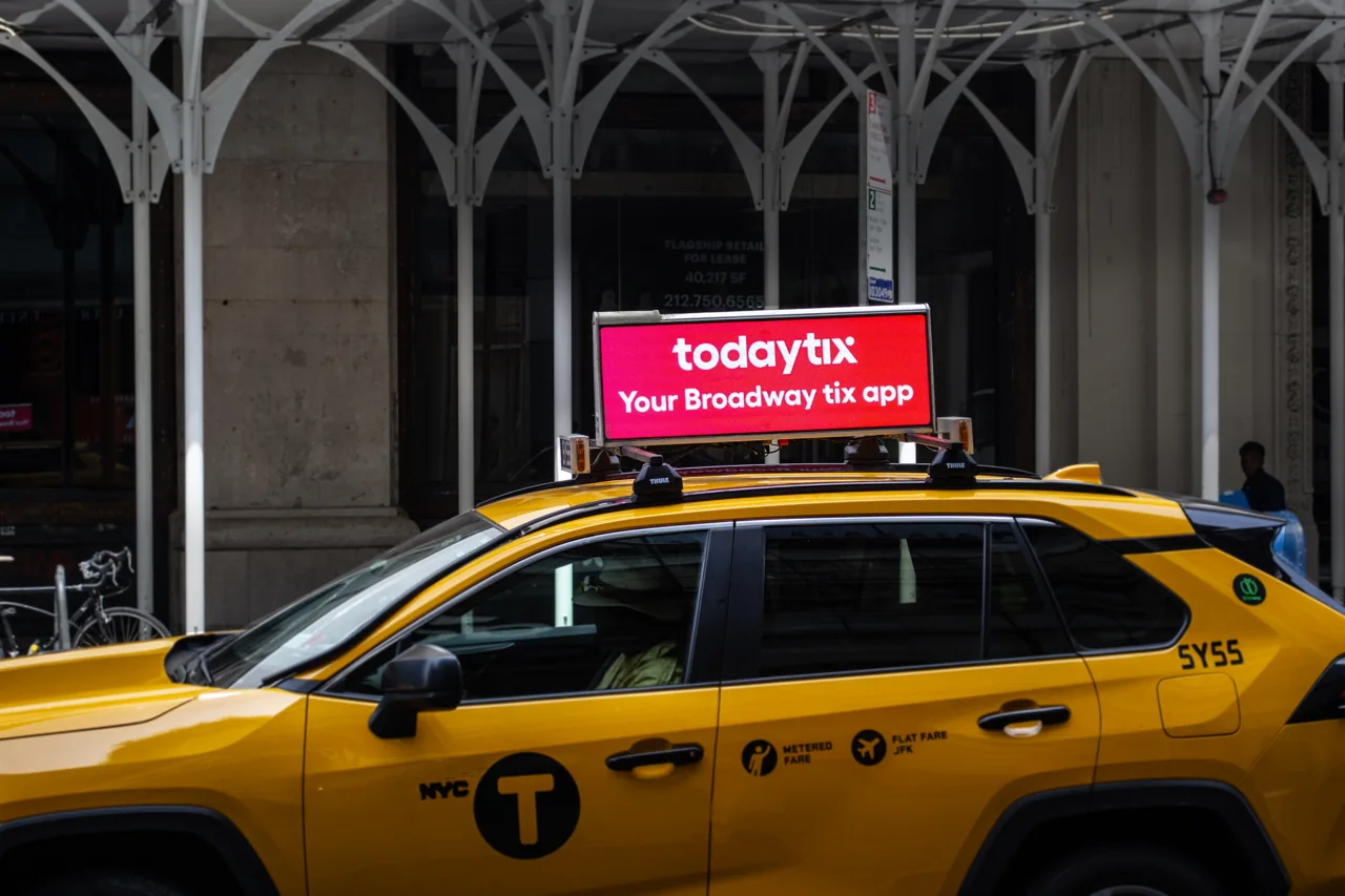 TodayTix 'Your Broadway tix app' running on a SOMO digital taxi-top screen atop a NYC yellow cab