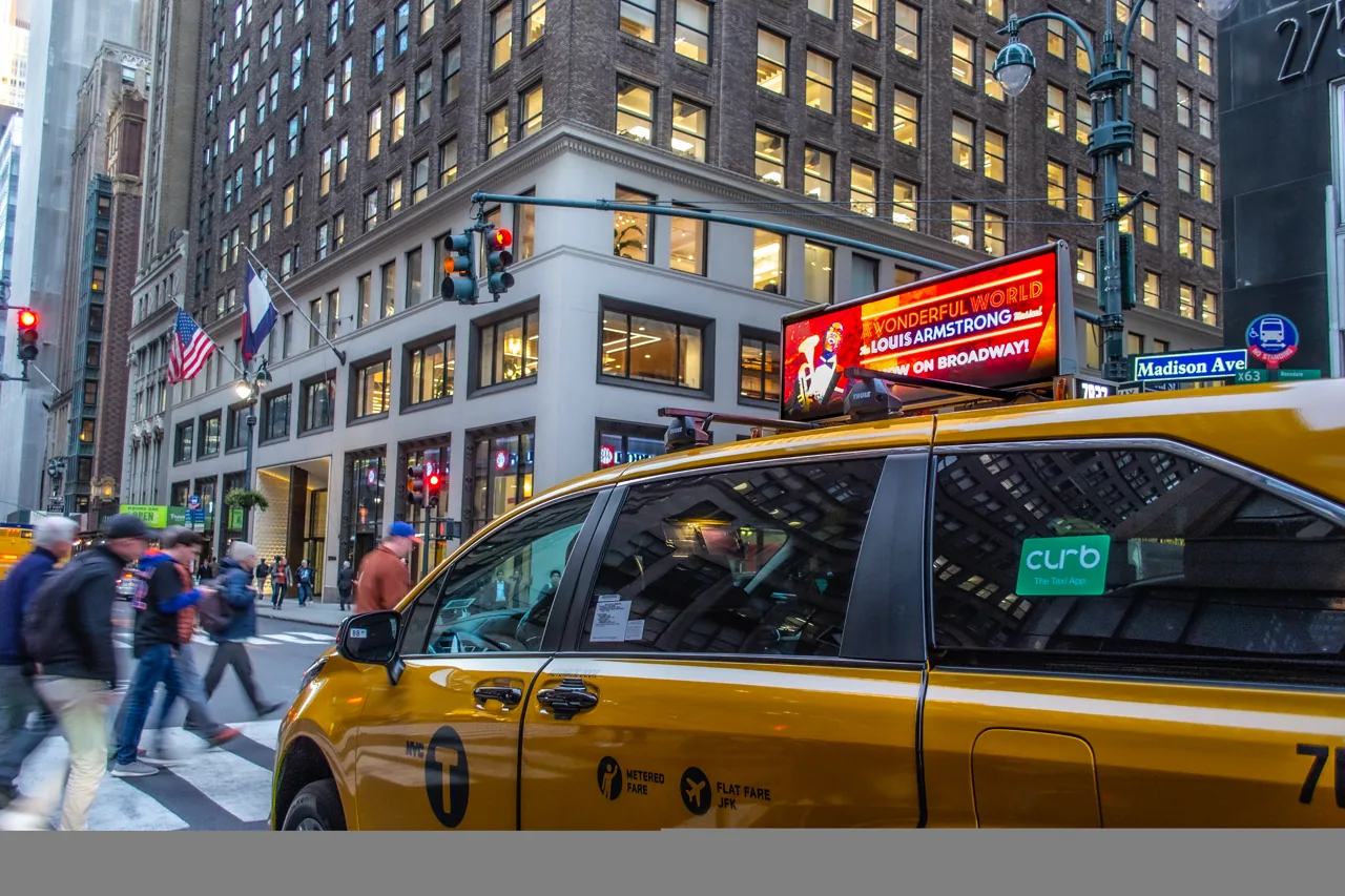 Digital taxi-top DOOH creative on a NYC yellow cab on Madison Avenue