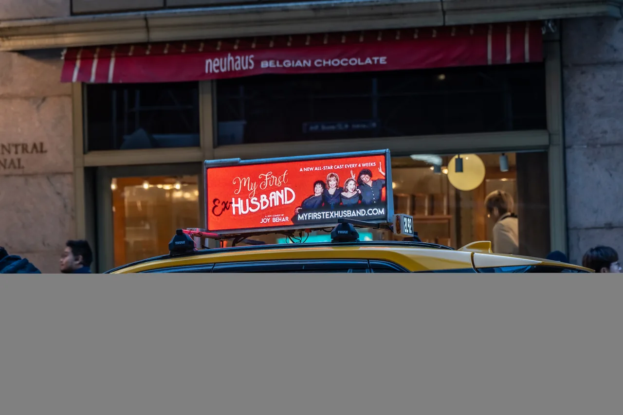 'My First Husband' branded ad on a SOMO taxi-top digital display, NYC yellow cab
