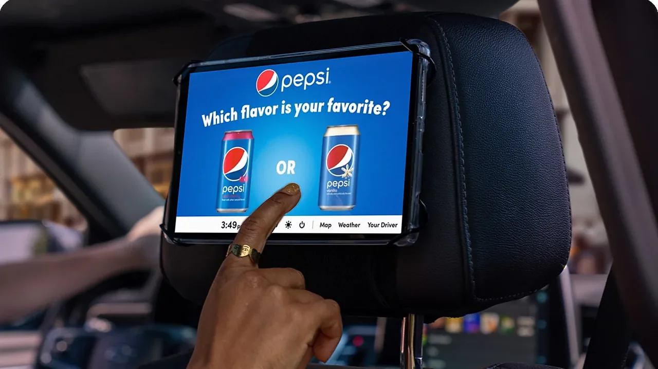 In-car backseat tablet showing a live Pepsi ad on the physical rideshare screen (T-Mobile Advertising Solutions rideshare in-car format)