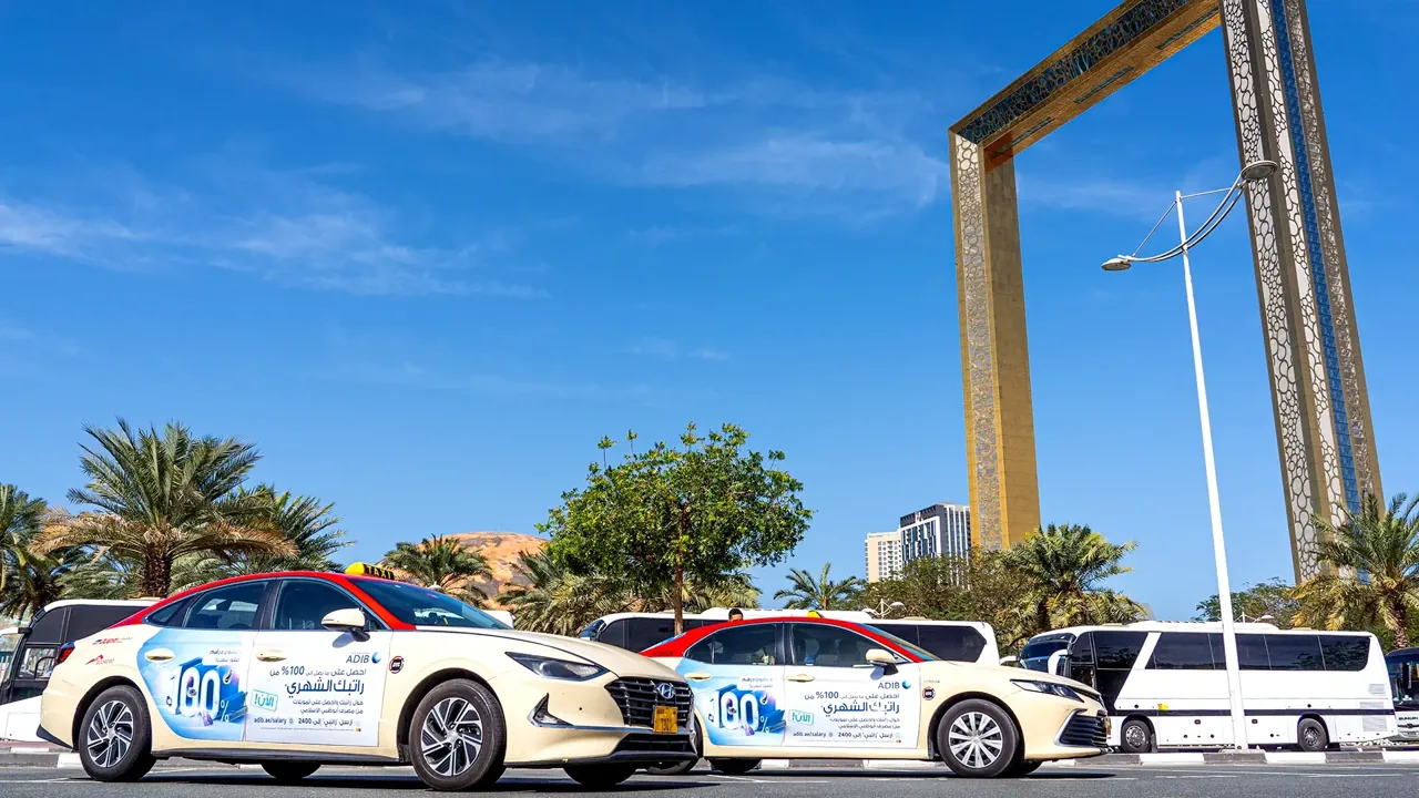 ADIB (Abu Dhabi Islamic Bank) blue-and-white full taxi wrap on a Dubai RTA taxi (Taxi Advertising)