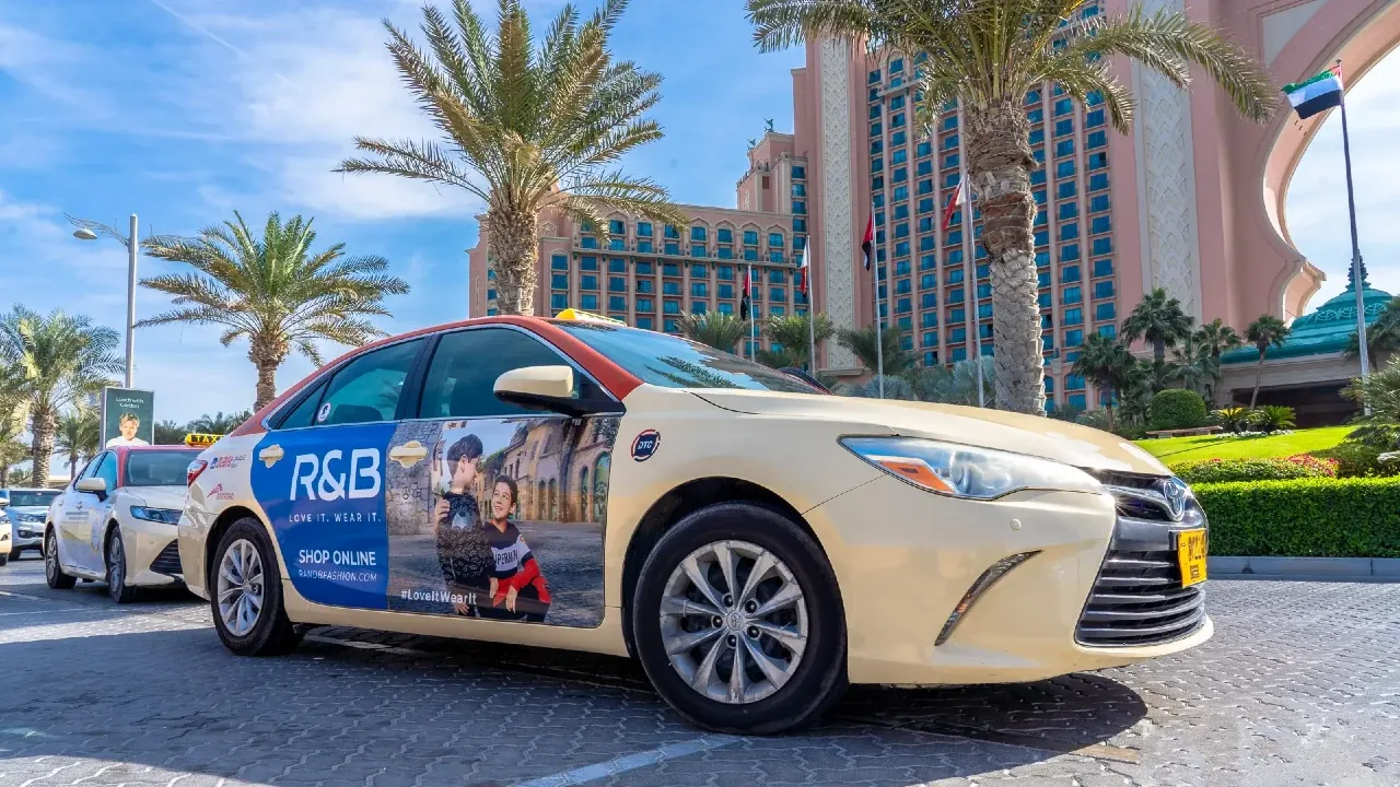 R&B taxi wrap showing tailored blazers and abayas graphics on a Dubai taxi (Taxi Advertising)