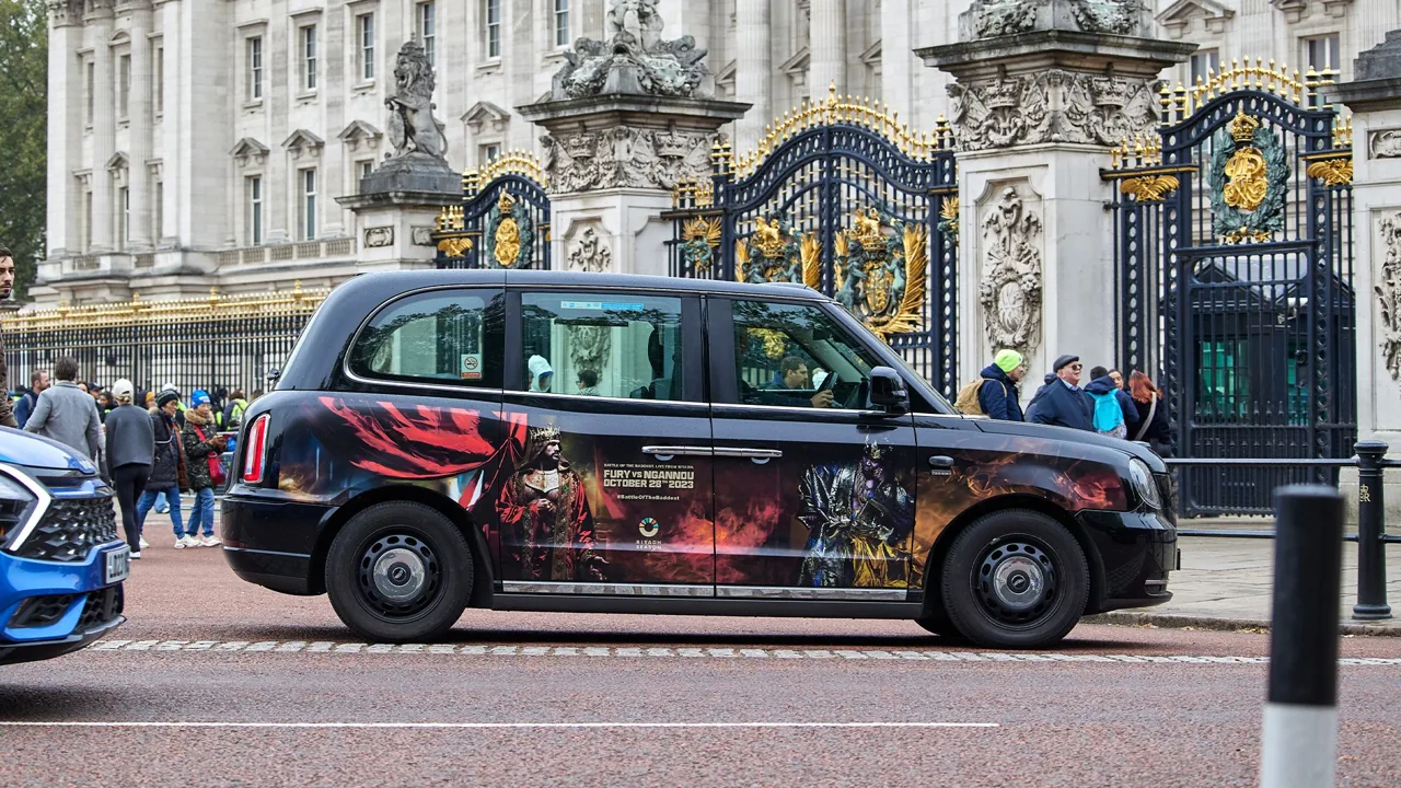 Full-livery wrapped London black cab parked by the Buckingham Palace gates (Transport Media taxi advertising gallery)