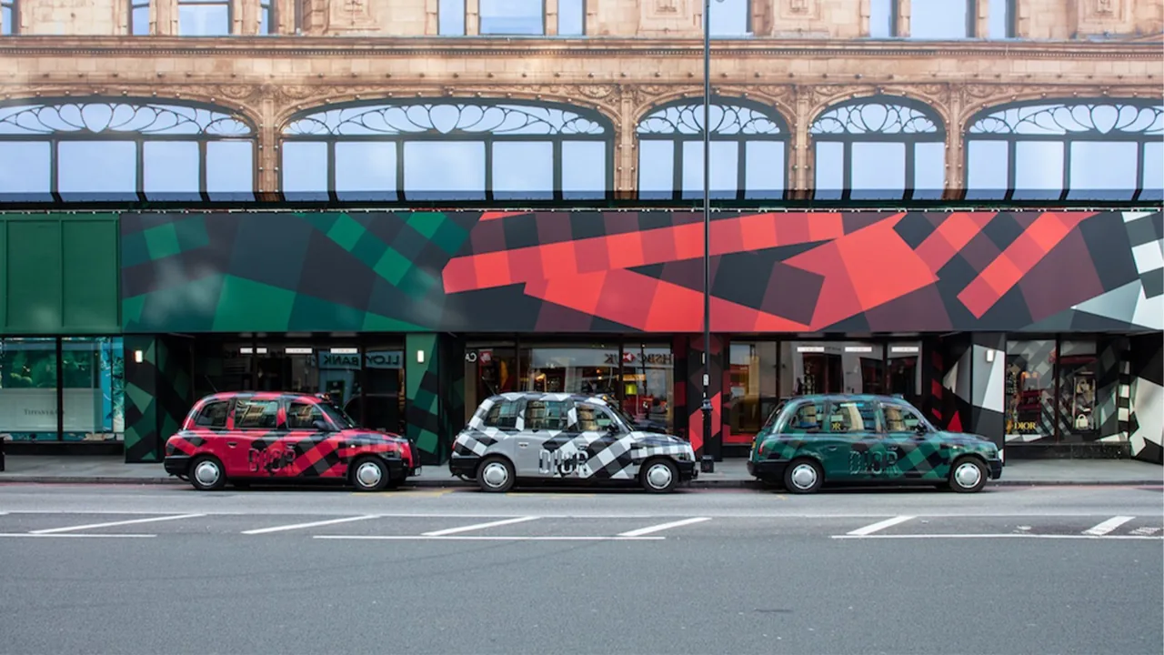 Fleet of colour-wrapped black cabs (red/black/green liveries) outside a London store (Transport Media taxi advertising gallery)
