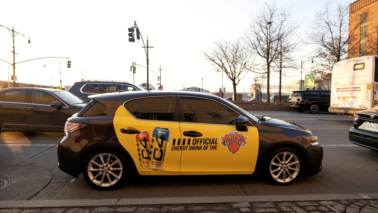 Vugo rideshare vehicle wrap advertising shown at street level (Vugo official site)