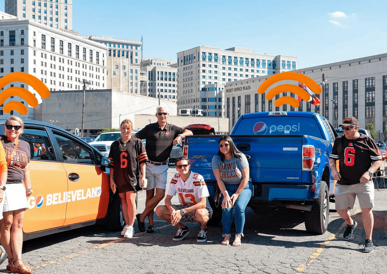 Pepsi 'Go Believeland' wrapped car and a Pepsi-branded pickup truck tailgating outside a Cleveland Browns game (Wrapify branding visible on tailgate)