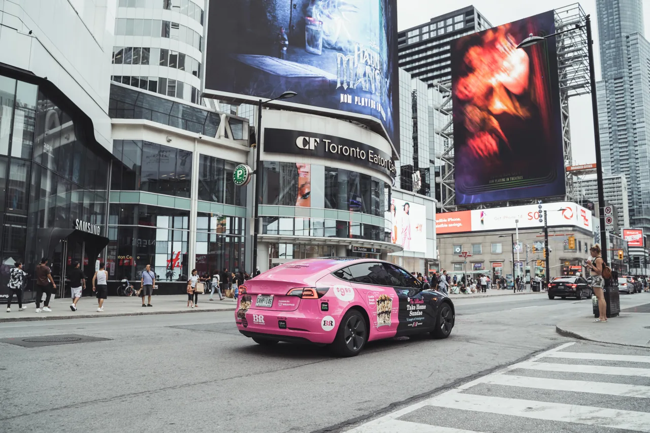 Baskin Robbins wrapped vehicle driving through a busy urban street (Wrapped Media campaign)