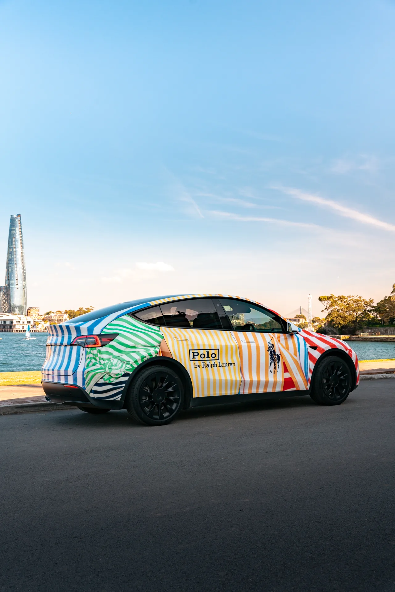 Polo by Ralph Lauren colourful striped full wrap on a Tesla Model Y at Sydney Harbour (Barangaroo)